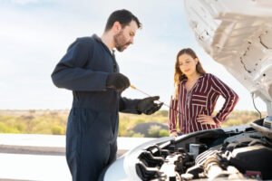 Young woman looking at the mechanic checking the oil level